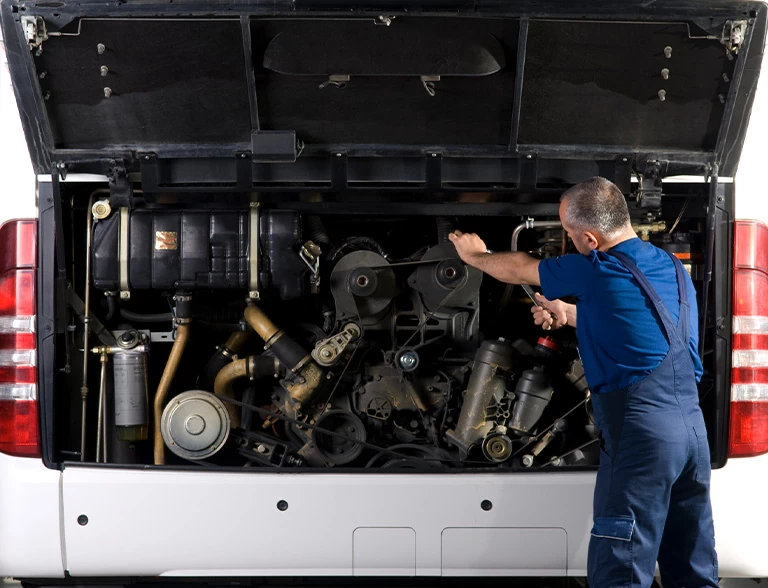 Mężczyzna naprawia autobus