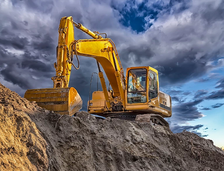 Koparka na&nbsp;tle górki